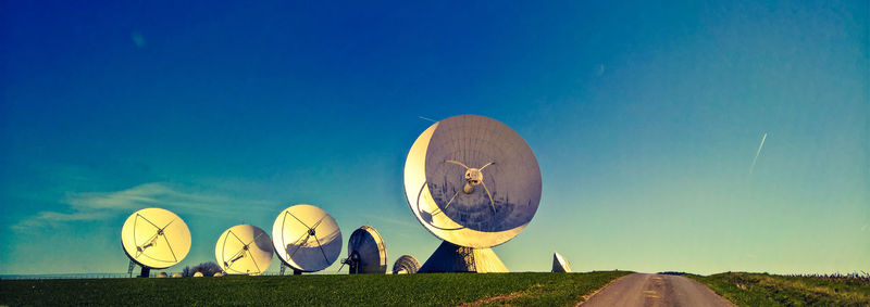 Satellite dish on field against sky