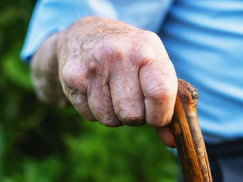 Midsection of senior man holding walking cane