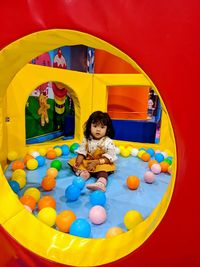 A little girl playing with colorful balls