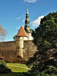 Bell tower of the church of st nicholas in tallinn, estonia, seen behind a turret in the city wall