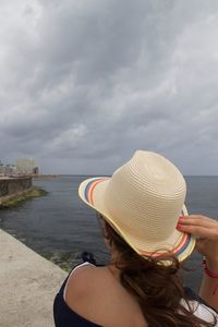 Rear view of woman in sea against sky