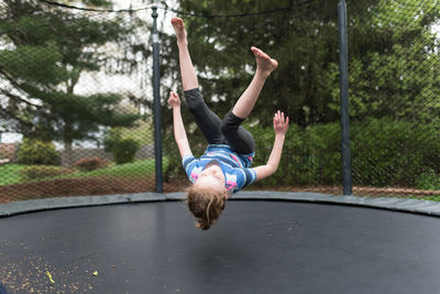 Playful girl jumping on trampoline at park