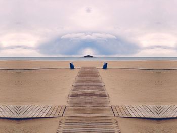 Pier on sea against cloudy sky