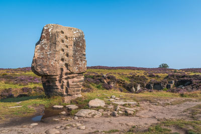 Stone on moor against clear sky