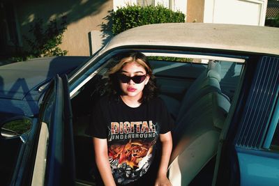 Portrait of young woman sitting in car