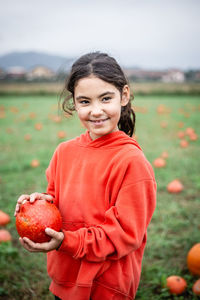 Portrait of girl holding pumpkin