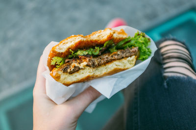 Cropped image of woman holding burger