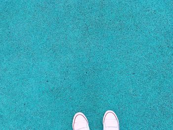 Low section of person standing on blue floor