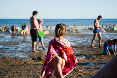 People on beach against clear sky