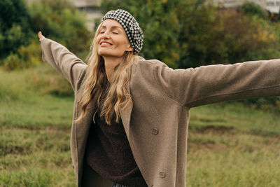 Portrait of young woman standing on field