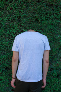 Rear view of man with head in bushes