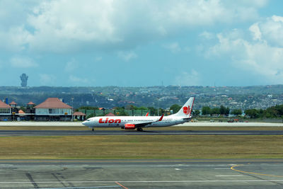 Airplane on airport runway against sky