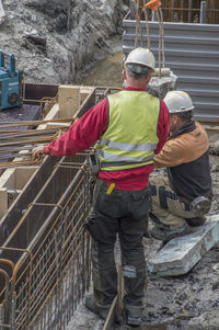 Rear view of men working at construction site