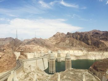 Scenic view of dam and mountains against sky