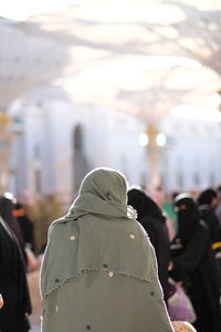 Rear view of people standing in city during winter