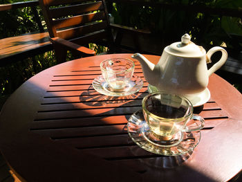 Tea cups and pots on table during sunny day