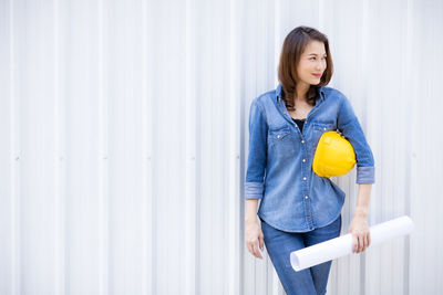 Portrait of woman standing against wall