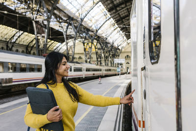 Woman looking at train at railroad station