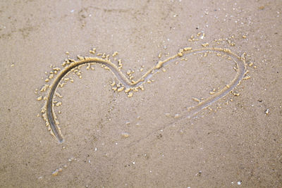 High angle view of heart shape in sand at beach