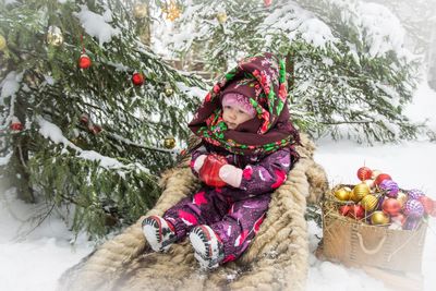 Young woman with christmas tree in snow