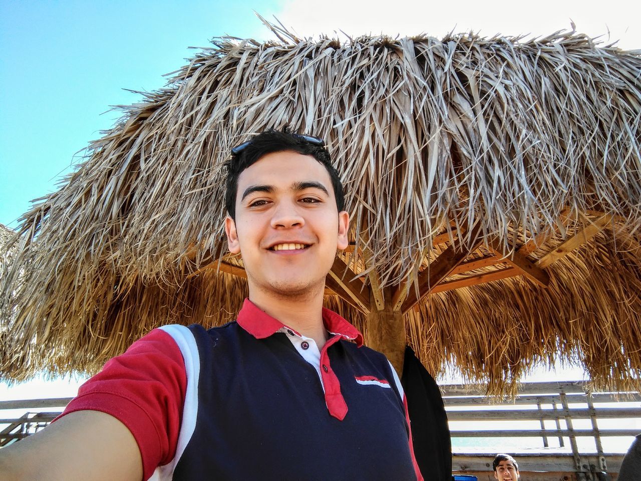 portrait, looking at camera, smiling, real people, one person, day, front view, standing, happiness, headshot, outdoors, lifestyles, sky, close-up, young adult, people