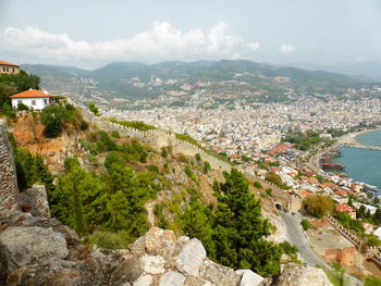 High angle view of townscape by sea against sky