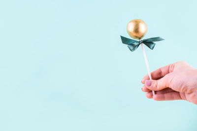 Close-up of hand holding blue background