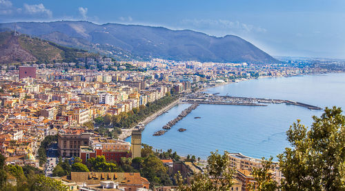 High angle view of townscape by sea against sky