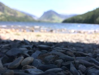 Close-up of pebbles on beach against sky