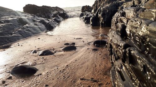 Rocks on beach against sky