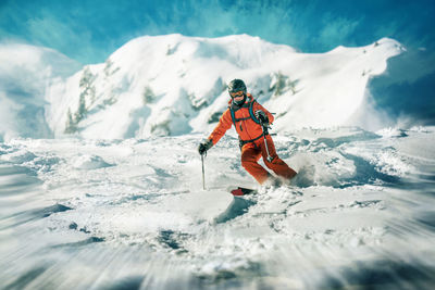 Low angle view of mature woman skiing on snow covered mountain