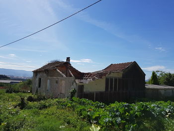 Abandoned house on field against sky