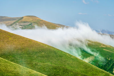 Scenic view of waterfall against sky