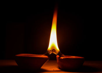 Close-up of lit diyas on table