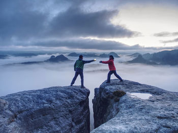 Men standing on rock against mountain