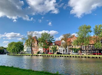 View of river by buildings against sky