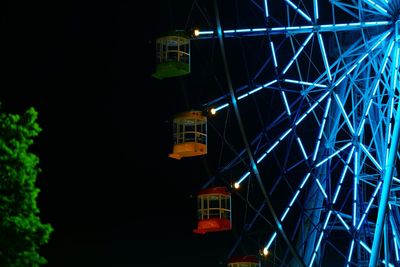 Low angle view of illuminated ferris wheel at night