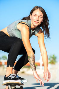 Young woman skateboarding on road