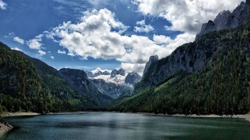 Scenic view of lake by mountains against sky