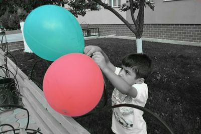 Boy standing on balloon balloons