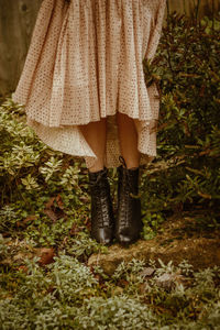 Low section of woman standing by plants