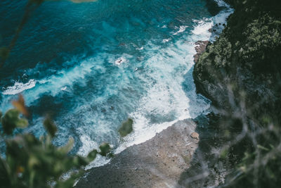High angle view of waves breaking on rocks