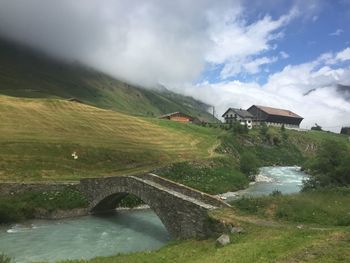 Scenic view of river by landscape against sky