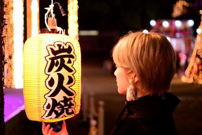 Side view of woman with illuminated text at night