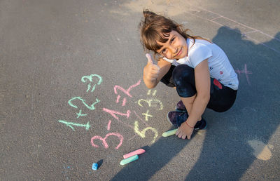 Cute girl writing on road