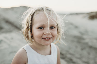 Portrait of preschool-aged girl smiling at beach