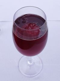 Close-up of wineglass on table against white background