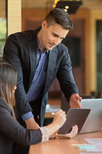 Full length of man using mobile phone on table