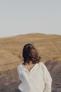 Woman standing on land against clear sky