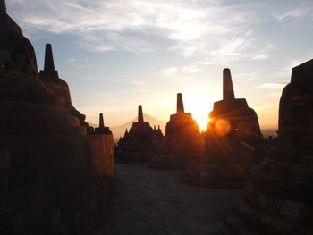 Panoramic view of temple against buildings at sunset